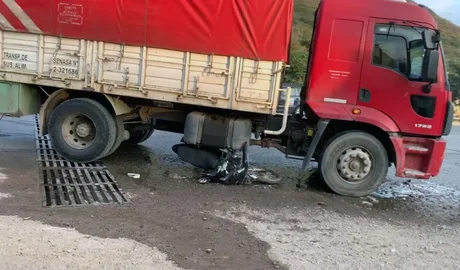 Una mujer chocó con su moto y quedó debajo de un camión